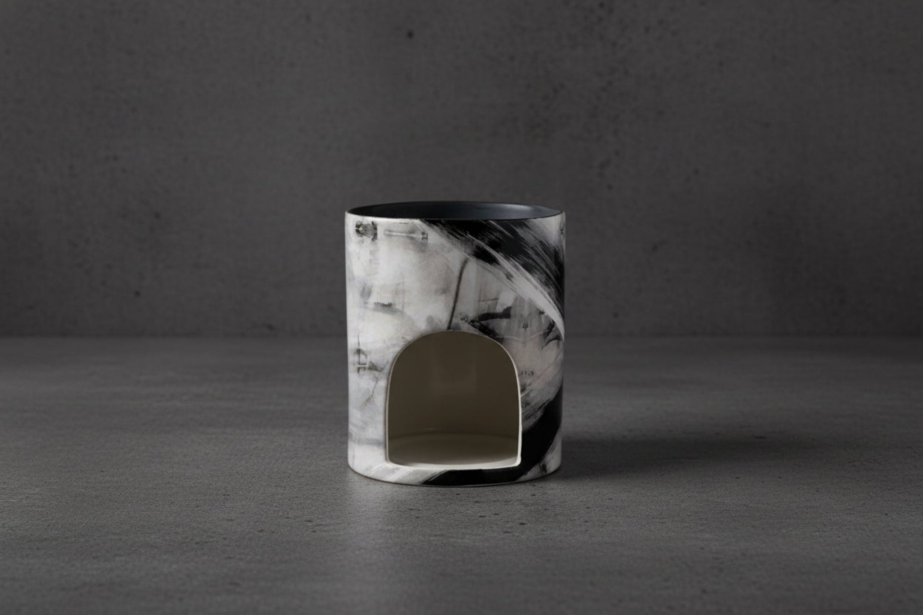 Marble-patterned candle holder on a concrete background