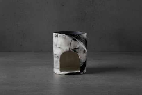 Marble-patterned candle holder on a concrete background