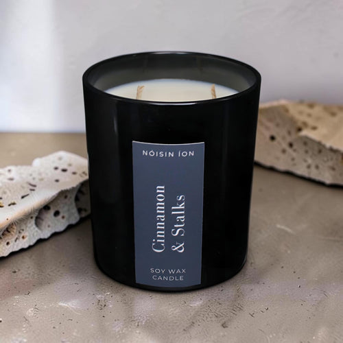 Cinnamon & Stalks luxury soy wax candle in a black gloss jar with a dark navy label by Nóisin Íon.