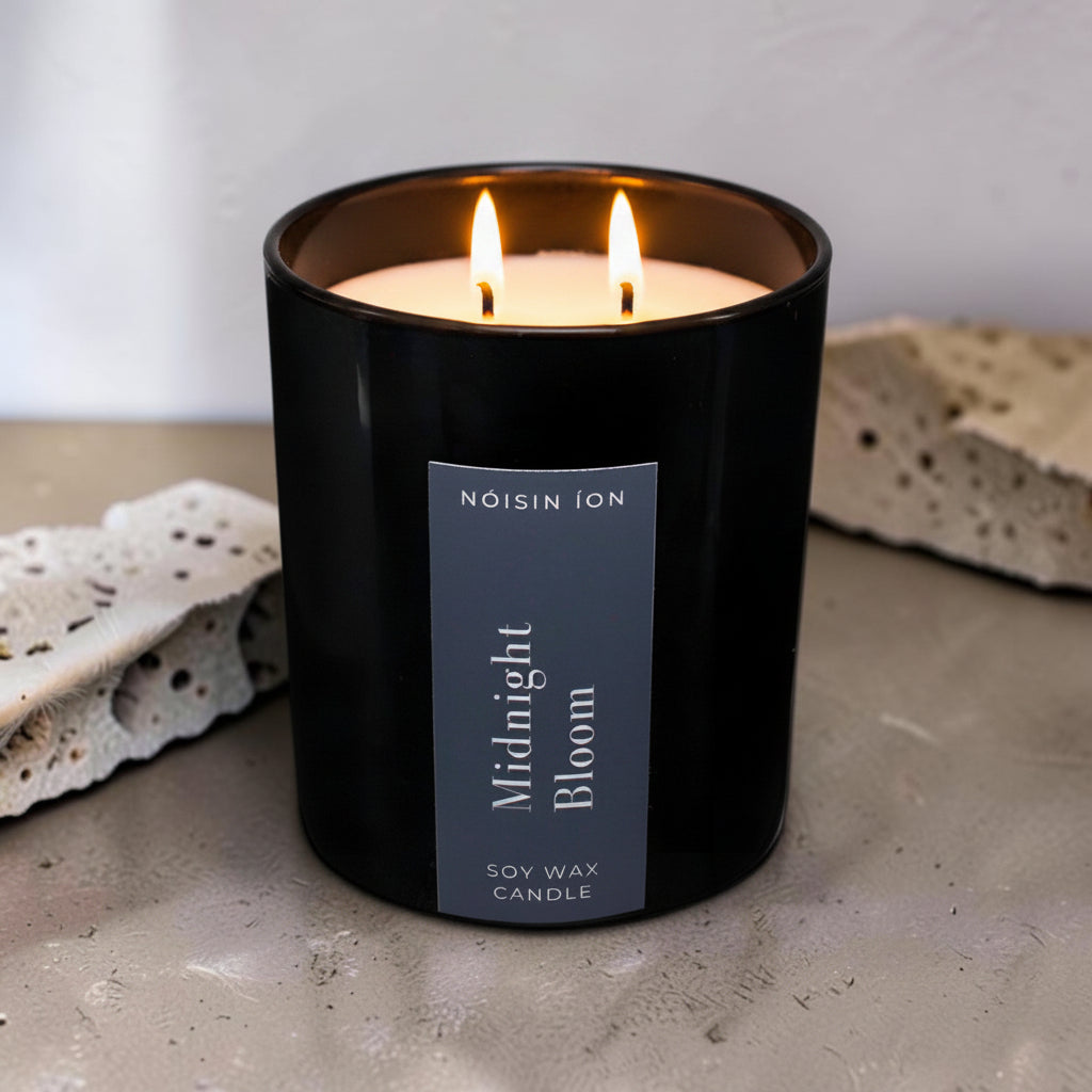 Lit Midnight Bloom luxury soy wax candle in a black gloss jar with elegant floral fragrance by Nóisin Íon.