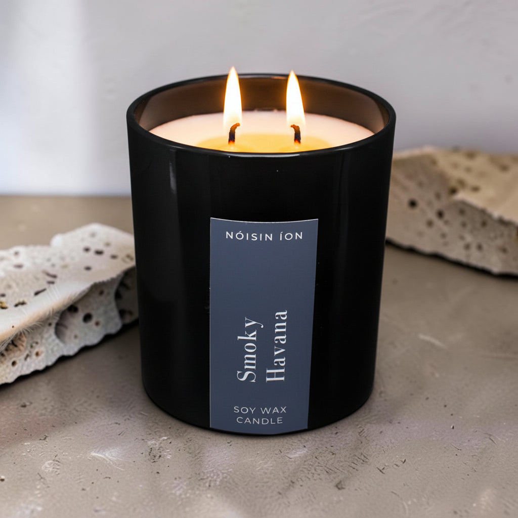 Lit Smoky Havana luxury soy wax candle in a black gloss jar with rich tobacco, spice and woody fragrance by Nóisin Íon.