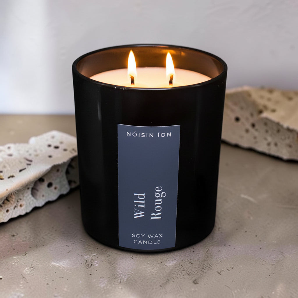Lit Wild Rouge luxury soy wax candle in a black gloss jar with a dark navy label by Nóisin Íon.