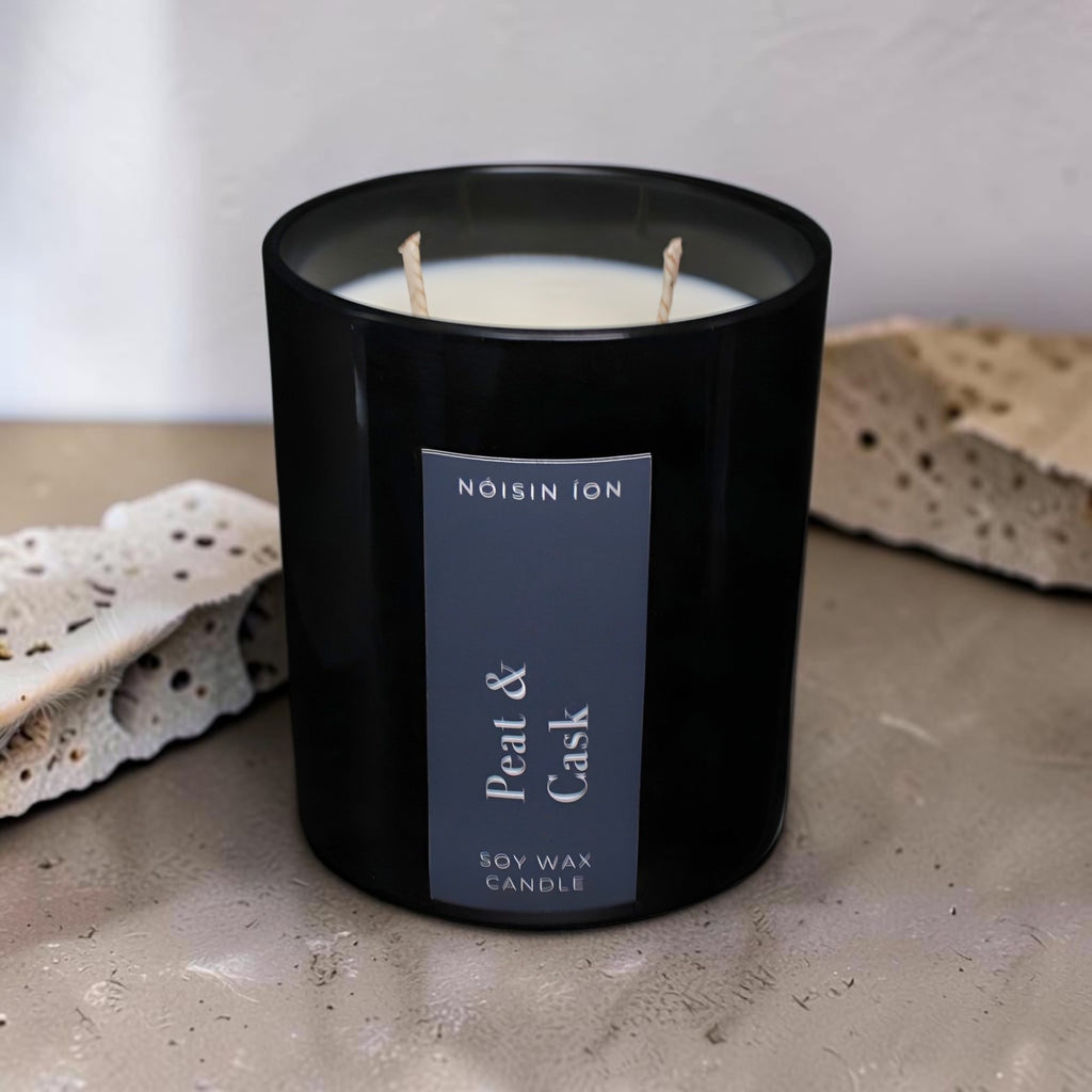 Peat & Cask luxury soy wax candle in a black gloss jar with a dark navy label by Nóisin Íon.