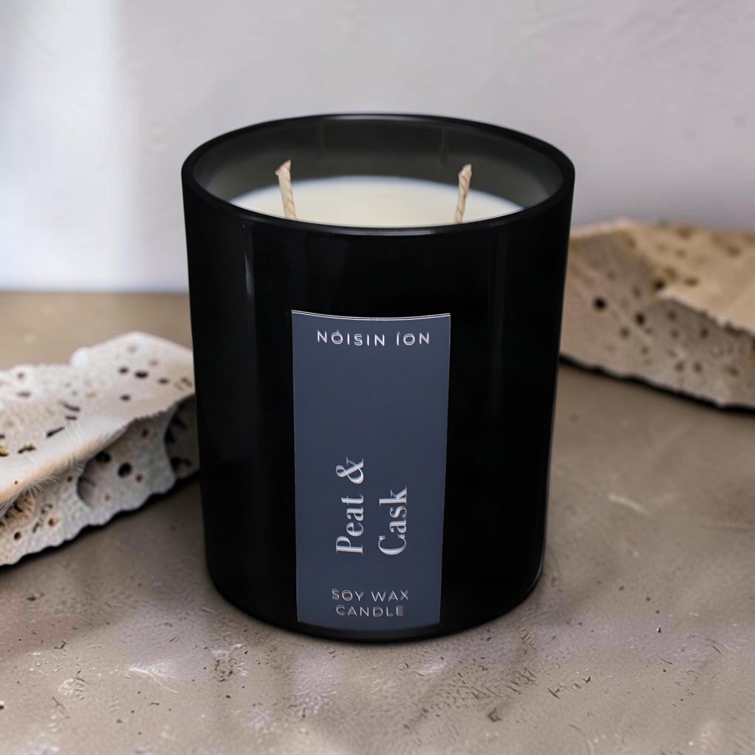 Peat & Cask luxury soy wax candle in a black gloss jar with a dark navy label by Nóisin Íon.
